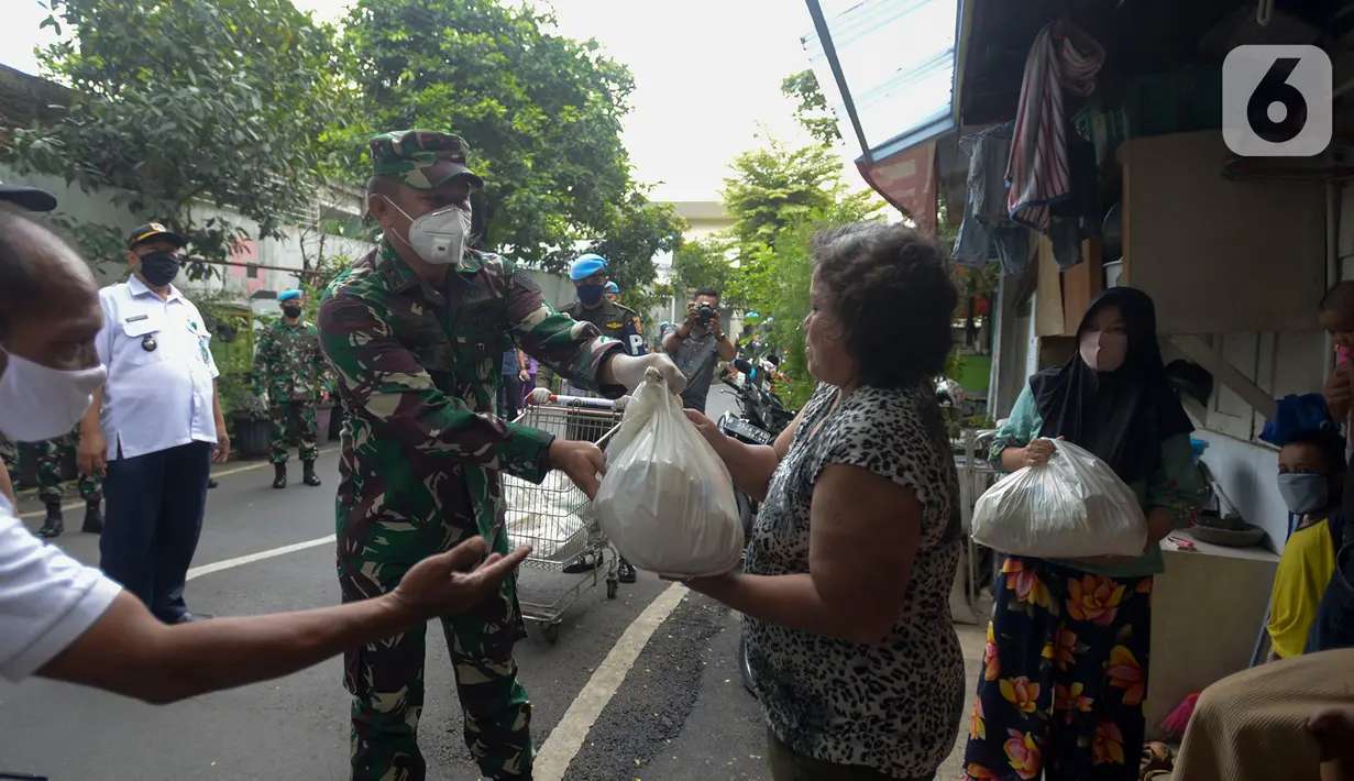 Anggota Paspampres memberikan sembako kepada warga di Kawasan Mako Paspampres,Jakarta, Rabu (15/4/2020). Donor daran dan pembagian sembako sebagai bentuk kepedulian kemanusian di tengah pandemi virus COVID-19. (merdeka.com/Imam Buhori)