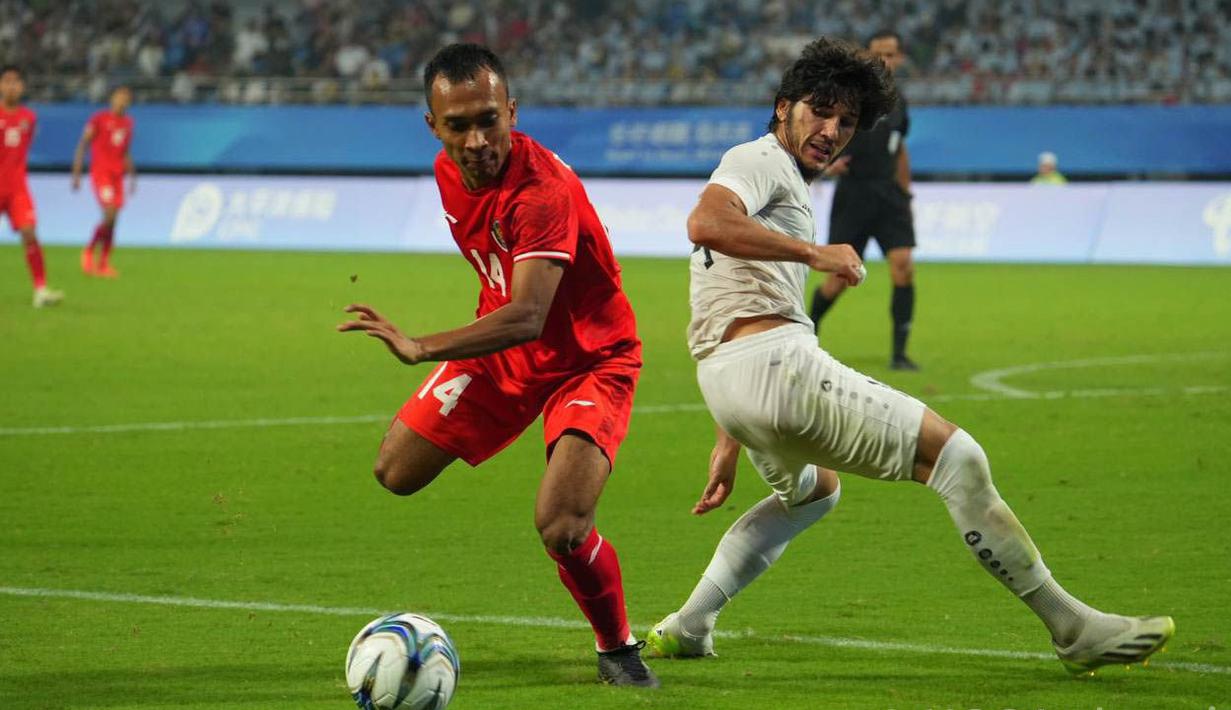 Pemain Timnas Indonesia U-24, Robi Darwis, berhasil melewati penjagaan pemain Timnas Uzbekistan U-24 dalam pertandingan 16 besar Asian Games 2022 yang berlangsung di Stadion Shangcheng Sports Centre, Kamis (28/9/2023). (Bola.com/NOC/Naif Al'as)