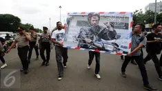 Koordinator KontraS, Haris Azhar (tengah) berjalan menuju Sekretariat Negara untuk menyampaikan Kartu Pos Desak Presiden Selesaikan Kasus Munir, Jakarta, Selasa (17/1). Kartu dikumpulkan dari masyarakat di 20 kota. (Liputan6.com/Helmi Fithriansyah)