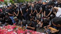 Pemain dan ofisial klub Arema FC berdoa dan menaburkan bunga untuk para korban kerusuhan Stadion Kanjuruhan Malang di Malang, Senin, 3 Oktober 2022. Aksi ini sebagai bentuk belasungkawa terhadap ratusan korban yang tewas dalam kerusuhan di Stadion Kanjuruhan Malang kemarin. (AP Photo/Achmad Ibrahim)