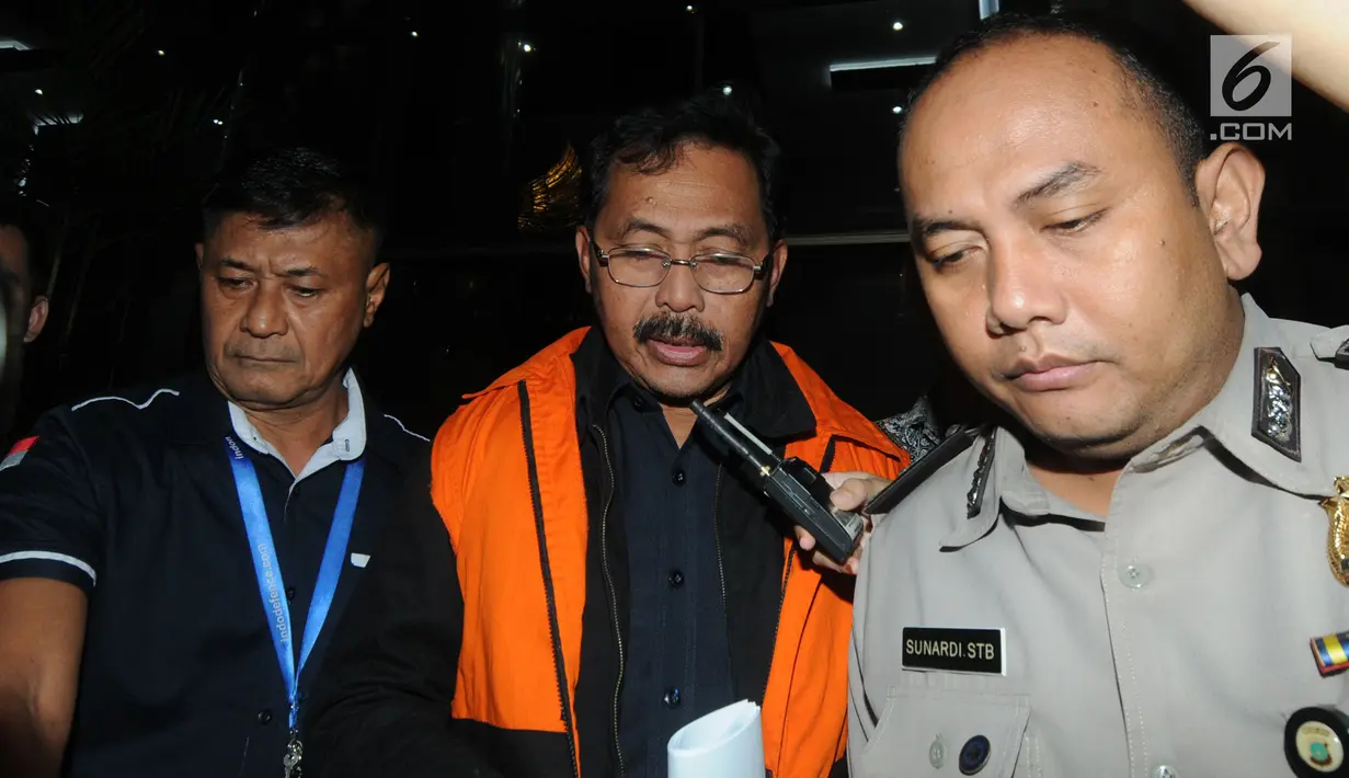 Gubernur Kepri Nurdin Basirun dikawal petugas usai menjalani pemeriksaan 1 x 24 jam di Gedung KPK, Jakarta, Jumat dini hari (12/7/2019). Nurdin Basirun resmi ditahan KPK bersama tiga tersangka dengan barang bukti berbagai pecahan mata uang senilai Rp666.812.189,56. (merdeka.com/Dwi Narwoko)