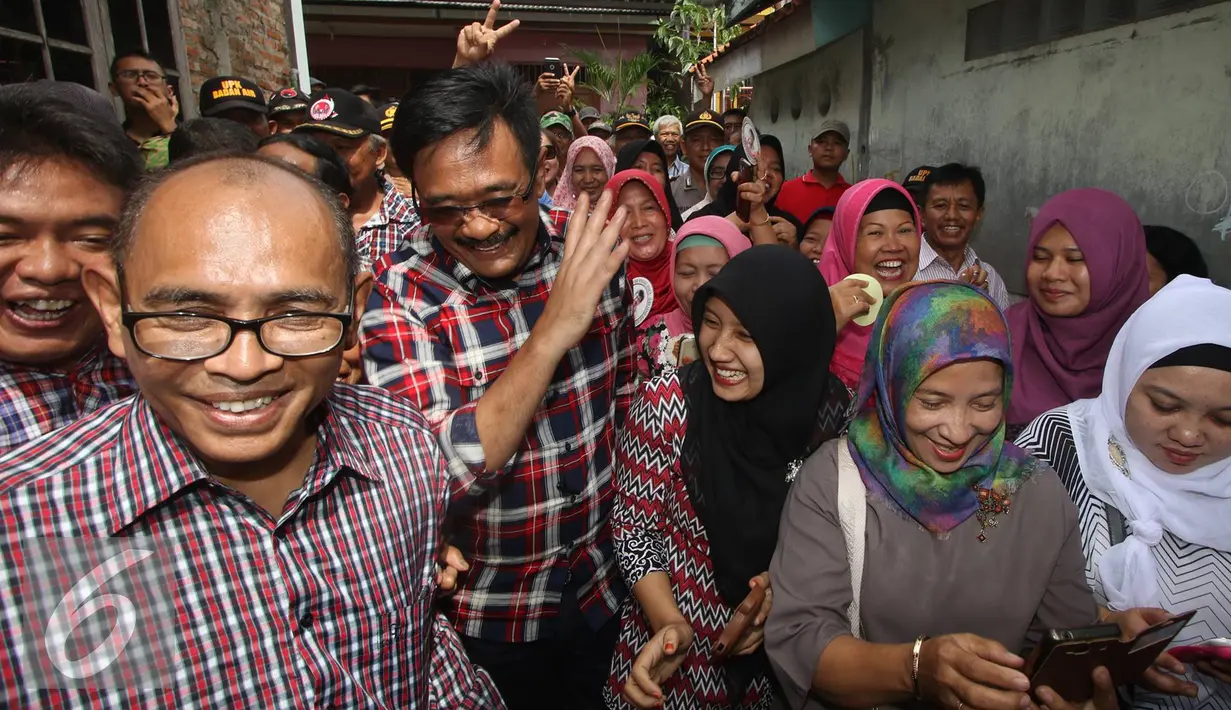 Cawagub DKI Jakarta Djarot Saiful Hidayat diantara warga setempat saat mengunjungi kawasan Pasar Rebo, Jakarta Timur, Rabu (2/11). Djarot mengimbau agar warga membuang sampah pada tempatnya untuk mencegar banjir. (Liputan6.com/Immanuel Antonius)