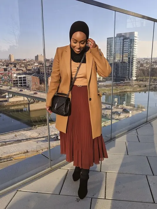 Cocok untuk OOTD musim dingin, kombinasikan long coat warna cokelat dengan rok plisket warna bata, kece! (Instagram/ayshaharun).