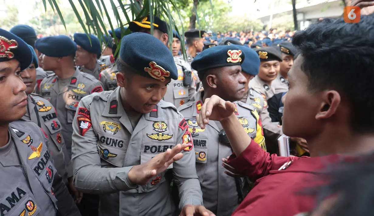Seorang petugas kepolisian berusaha menenangkan mahasiswa yang memprotes karena dihalangi saat hendak menuju gedung DPR untuk menyampaikan aspirasi di Jakarta, Kamis (27/8/2026). (KLY/Budy Santoso)