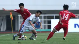 Bek Korea Utara, An Song II (kiri) berebut bola dengan pemain Uzbekistan, Nurulioev Sukhrob pada laga perdana PSSI Anniversary 2018 di Stadion Pakansari, Kab Bogor, Jumat (27/4). Laga berakhir imbang 2-2. (Liputan6.com/Helmi Fithriansyah)