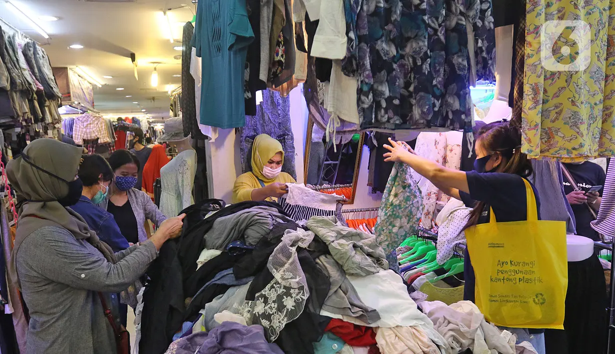 Calon pembeli memilih pakaian bekas di salah satu kios Pasar Senen Blok III, Jakarta, Kamis (11/6/2020). Pasar yang tetap buka saat PSBB dengan pembatasan jam operasional ini akan kembali dibuka secara normal pada 15 Juni 2020 dengan aturan protokol kesehatan COVID-19. (Liputan6.com/Herman Zakharia)