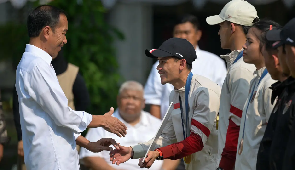 Presiden Joko Widodo menyalami peraih medali emas Indonesia di cabang olahraga panjat tebing Olimpiade Paris 2024, Veddriq Leonardo saat upacara penerimaan yang dilakukan di Istana Merdeka, Jakarta, pada Kamis 15 Agustus 2024. (BAY ISMOYO/AFP)