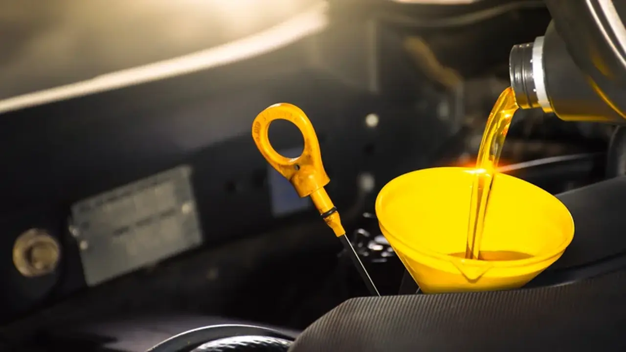 Proses Pengisian Oli Mesin Mobil Menggunakan Corong di Samping Dipstick .