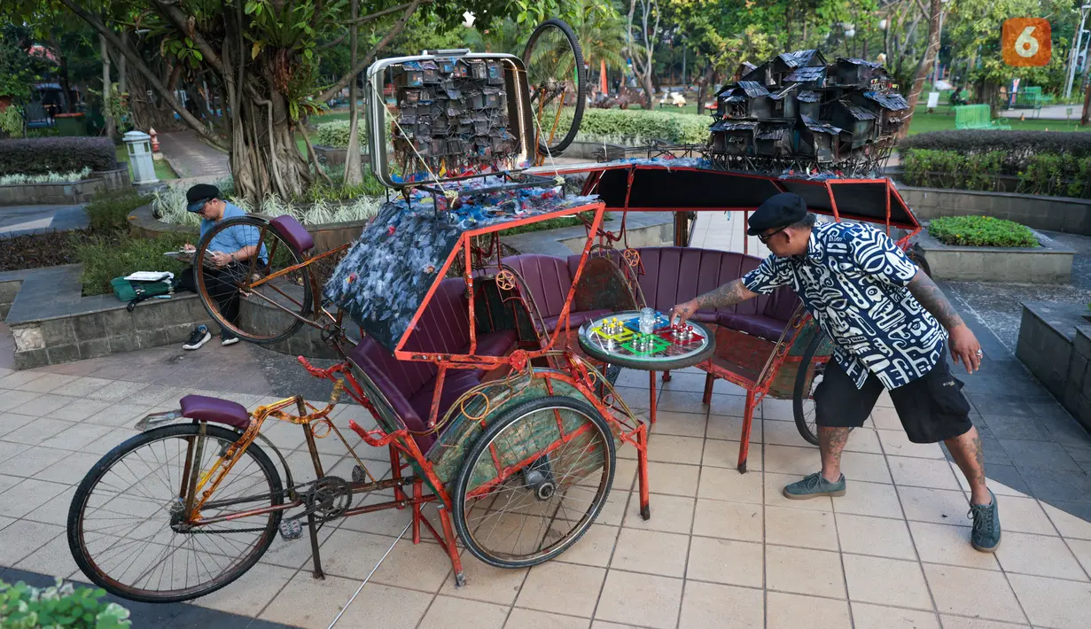 Pengunjung mengamati karya dalam pameran seni rupa kontemporer luar ruang Jakarta Provoke! di Taman Menteng, Jakarta Pusat, Jumat (17/7/2026). Pameran gratis yang berlangsung hingga 26 Juli 2026 ini menghadirkan 25 karya dari 25 seniman dan kolektif tentang dinamika kehidupan Jakarta. (KLY/Budy Santoso)