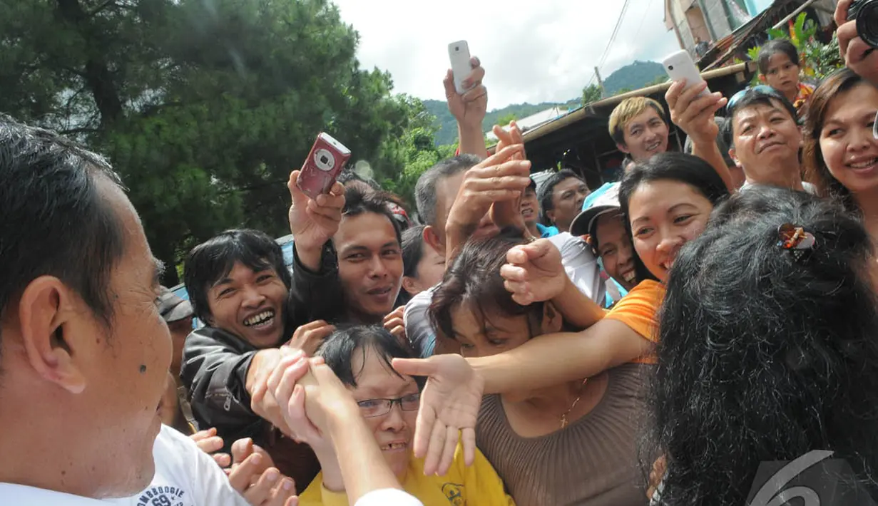 Para warga sekitar pasar langsung menyerbu Jokowi untuk bersalaman, Manado, Sabtu (9/4/2014) (Liputan6.com/Herman Zakharia).