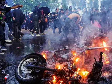 Para pengunjuk rasa membakar sepeda motor dalam sebuah demonstrasi menentang revisi Undang-Undang Tentara Nasional Indonesia (UU TNI) di depan Kompleks Parlemen di Jakarta pada 27 Maret 2025. (AZWAR IPANK/AFP)