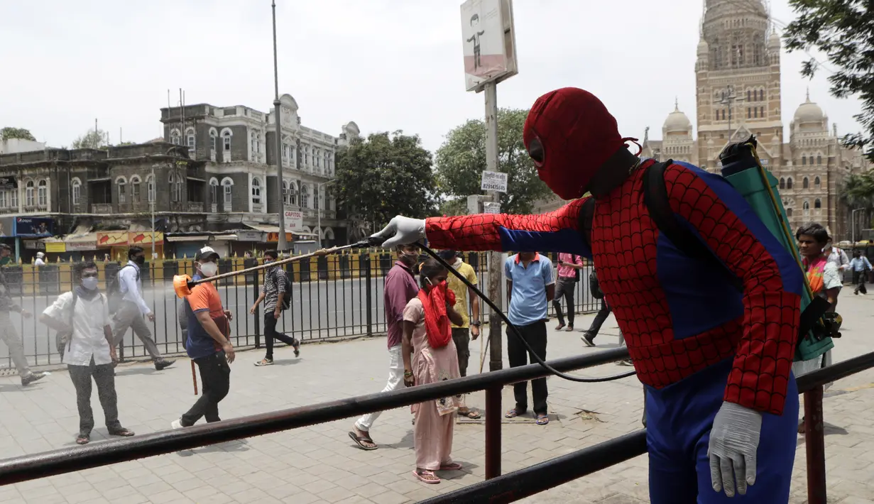 Pekerja sosial India Ashok Kurmi berpakaian seperti Spider Man mendesinfeksi daerah di sekitar stasiun kereta Chhatrapati Shivaji Maharaj selama lockdown yang diberlakukan di Mumbai, Rabu (21/4/2021). Kegiatan tersebut dilakukan untuk mengekang penyebaran COVID-19 di Mumbai. (AP Photo/Rajanish Kakad