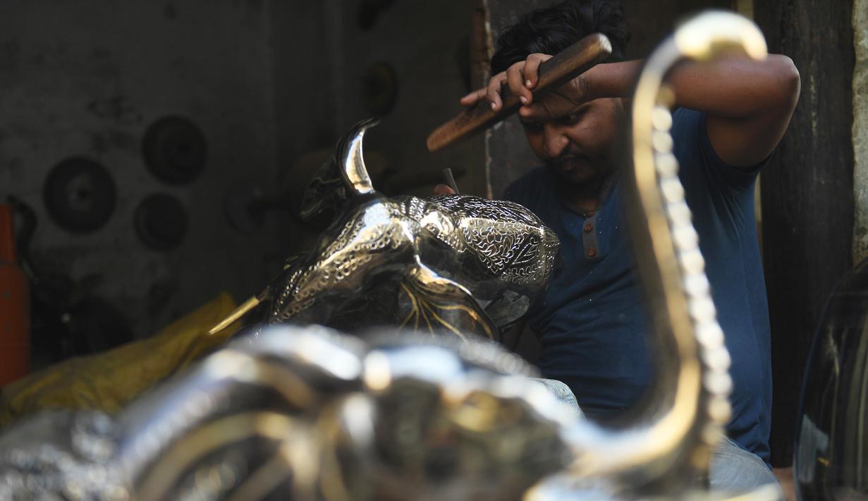 Perajin menyelesaikan kerajinan tangan dari kuningan di sebuah bengkel di Karachi (19/11/2019). Karachi merupakan salah satu pusat kerajinan kuningan terbaik di Pakistan. (AFP Photo/Asif Hassan)
