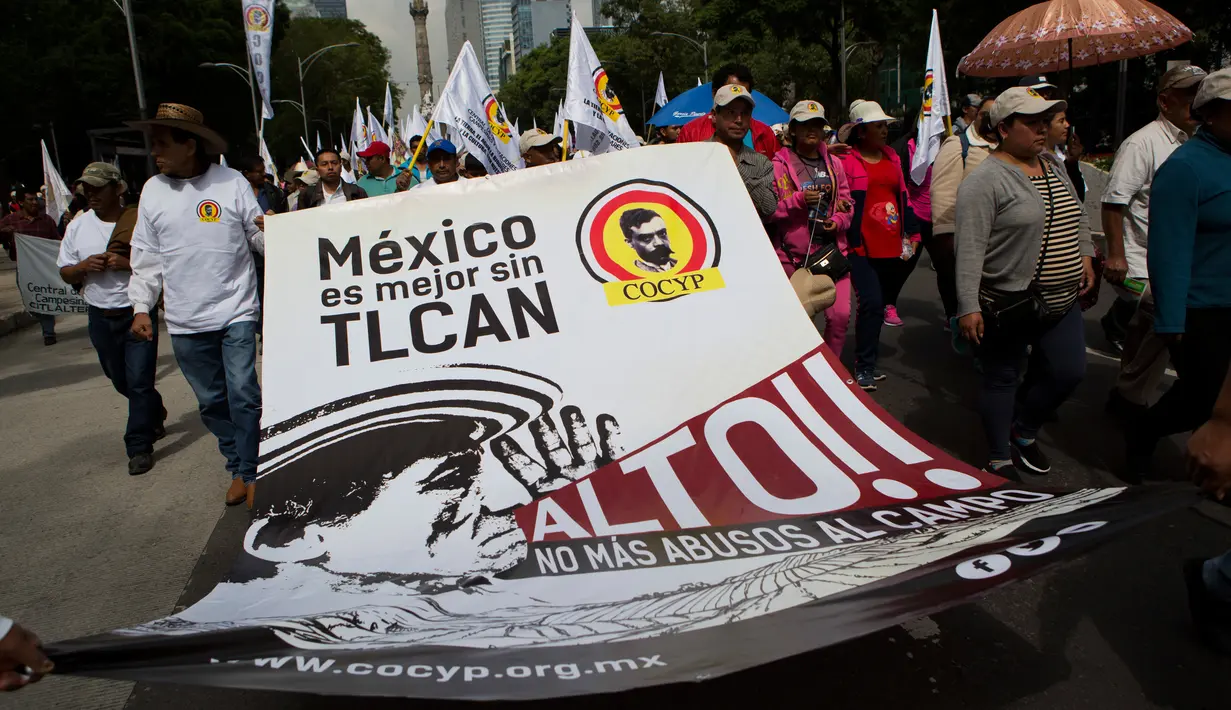 Petani Meksiko membentangkan spanduk saat melakukan demontrasi terkait North American Free Trade Agreement (NAFTA) di Mexico City (26/7). (AP Photo / Rebecca Blackwell)