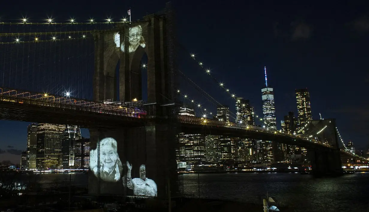 Gambar korban diproyeksikan pada Jembatan Brooklyn saat Hari Peringatan COVID-19 di Brooklyn, New York, Amerika Serikat, 14 Maret 2021. Kota New York mencatatkan kematian tertinggi akibat virus corona COVID-19 di Amerika Serikat. (Kena Betancur/AFP)