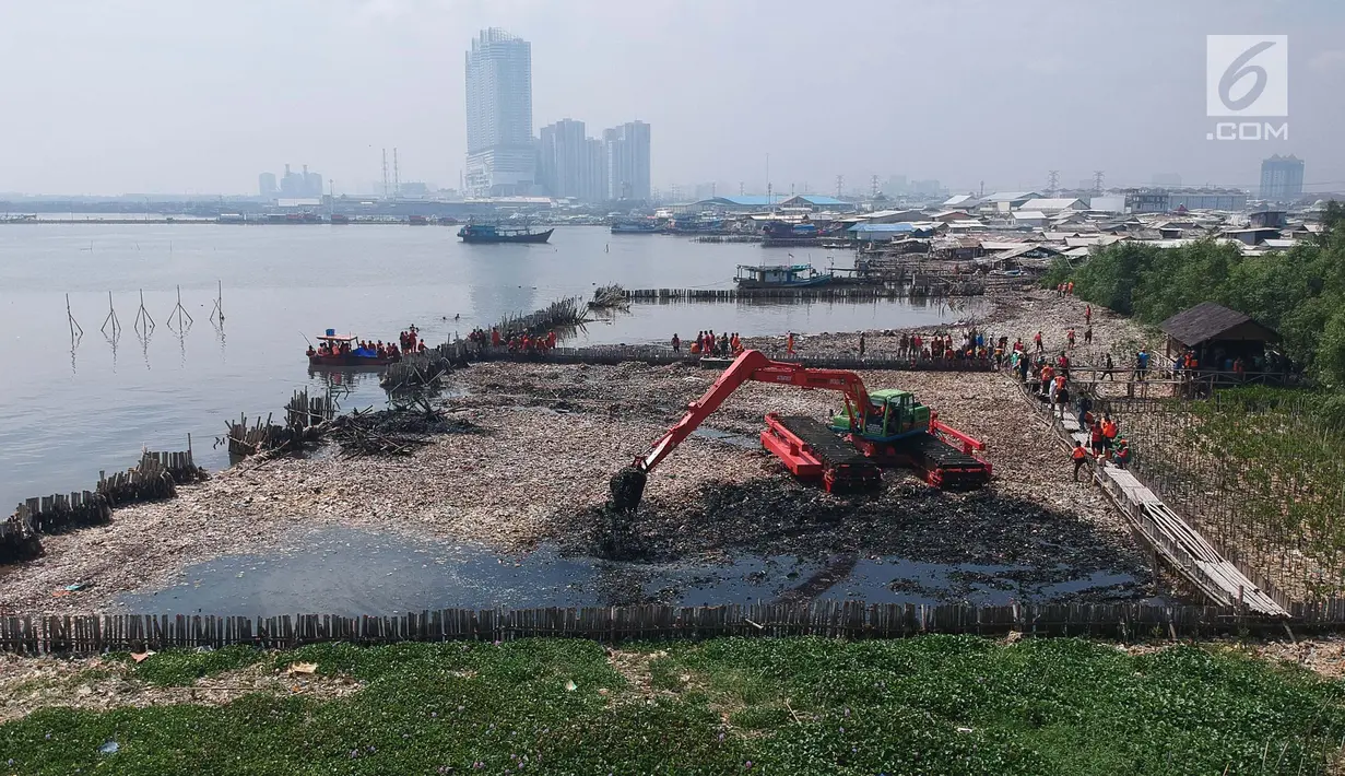 Petugas dengan menggunakan eskavator melakukan pengerukan sampah di kawasan Hutan Mangrove Ecomarine Muara Angke, Jakarta Utara, Minggu (18/3). Sampah itu terkumpul akibat gulungan ombak yang membawa sampah ke bibir pantai. (Liputan6.com/Arya Manggala)