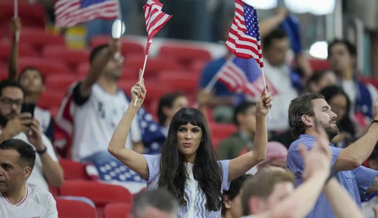 Seorang fans wanita tim Amerika Serikat menyemangati timnya sebelum dimulainya pertandingan grup B Piala Dunia 2022 Qatar antara Inggris dan Amerika Serikat di Stadion Al Bayt di Al Khor, Qatar, Sabtu (26/11/2022). Di pertandingan ini Inggris dan Amerika Serikat bermain imbang 0-0. (AP Photo/Ashley Landis)