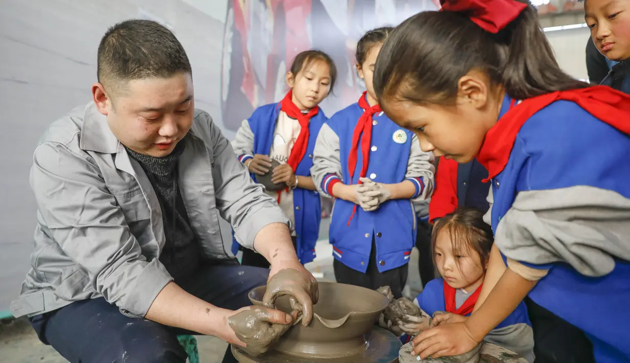 Sejumlah siswa sekolah dasar mencoba membuat porselen di bengkel kerja porselen Ru di Baofeng, Provinsi Henan, China, 15 November 2020. Baofeng dikenal sebagai produsen porselen Ru, satu dari lima porselen yang tersohor selama era Dinasti Song (960-1279) pada zaman China kuno. (Xinhua/He Wuchang)