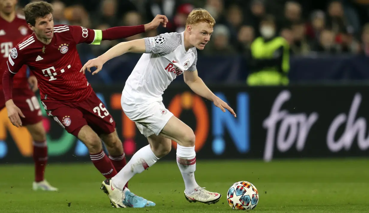 Gelandang RB Salzburg Nicolas Seiwald berebut bola dengan penyerang Bayern Munchen Thomas Mueller dalam leg pertama 16 besar Liga Champions di Red Bull Arena, Kamis dini hari WIB (17/2/2022). Bayern Munchen meraih hasil imbang 1-1 saat bertandang ke markas RB Salzburg. (AP Photo/Alexandra Beier)