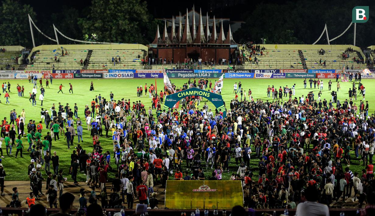 Masyarakat Padang turun ke dalam lapangan setelah laga leg kedua final Pegadaian Liga 2 2023/2024 di Stadion GOR Haji Agus Salim, Padang, Sabtu (9/3/2024). (Bola.com/Bagaskara Lazuardi)