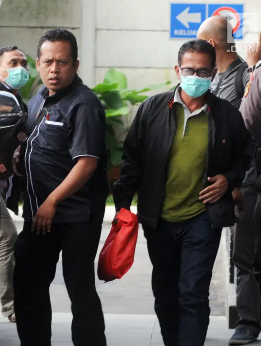 Bupati Mesuji Khamami (kanan) tiba di Gedung KPK, Jakarta, Kamis (24/1). KPK mengamankan sejumlah uang dalam kardus air mineral saat melakukan OTT terhadap Khamami. (Merdeka.com/Dwi Narwoko)