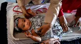 Seorang petugas kesehatan menimbang berat bayi dalam program pemeriksaan kesehatan bulanan untuk anak-anak di sebuah pusat layanan terpadu di Banda Aceh, Senin,  10 Agustus 2026. (AFP/ Chaideer Mahyuddin)