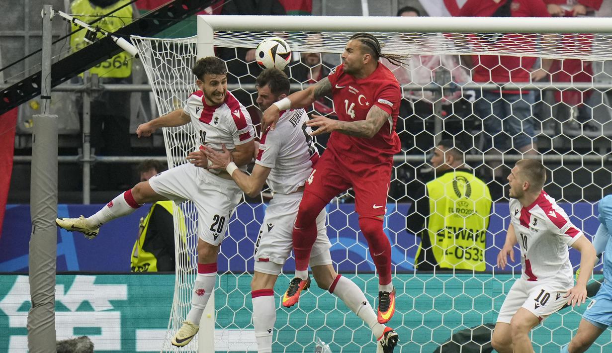 Bek Timnas Turki, Abdulkerim Bardakci (kanan) berebut bola di udara dengan dua pemain Timnas Georgia, Anzor Mekvabishvili (kiri) dan Solomon Kverkvelia pada laga matchday pertama Grup F Euro 2024 di Westfalenstadion, Dortmund, Jerman, Selasa (18/6/2024). (AP Photo/Alessandra Tarantino)