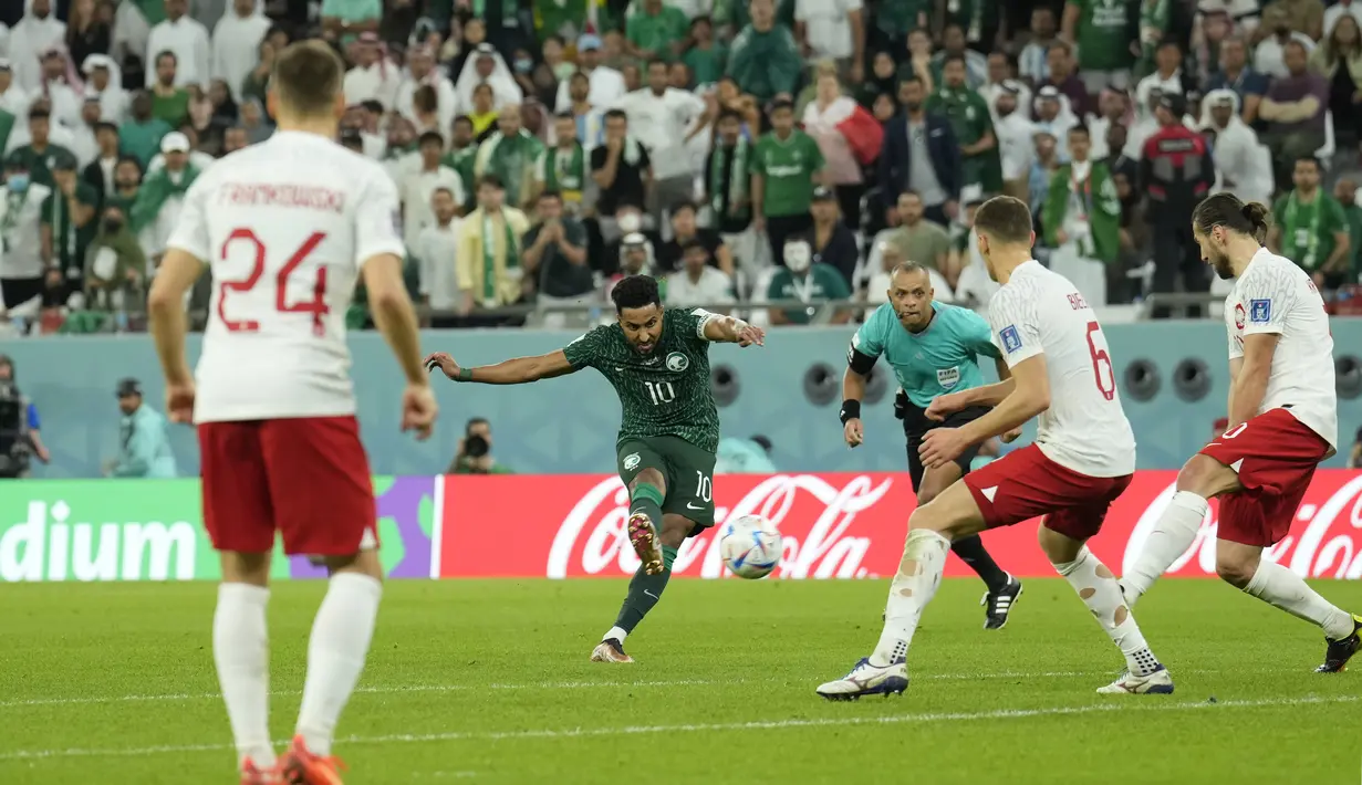 Gelandang Arab Saudi, Salem Al-Dawsari melakukan tembakan ke gawang di depan  pemain Polandia, Krystian Bielik selama pertandingan grup C Piala Dunia 2022 Qatar di Education City Stadium di Al Rayyan, Qatar, Sabtu (26/11/2022). Polandia menang atas Arab Saudi dengan skor 2-0. (AP Photo/Francisco Seco)