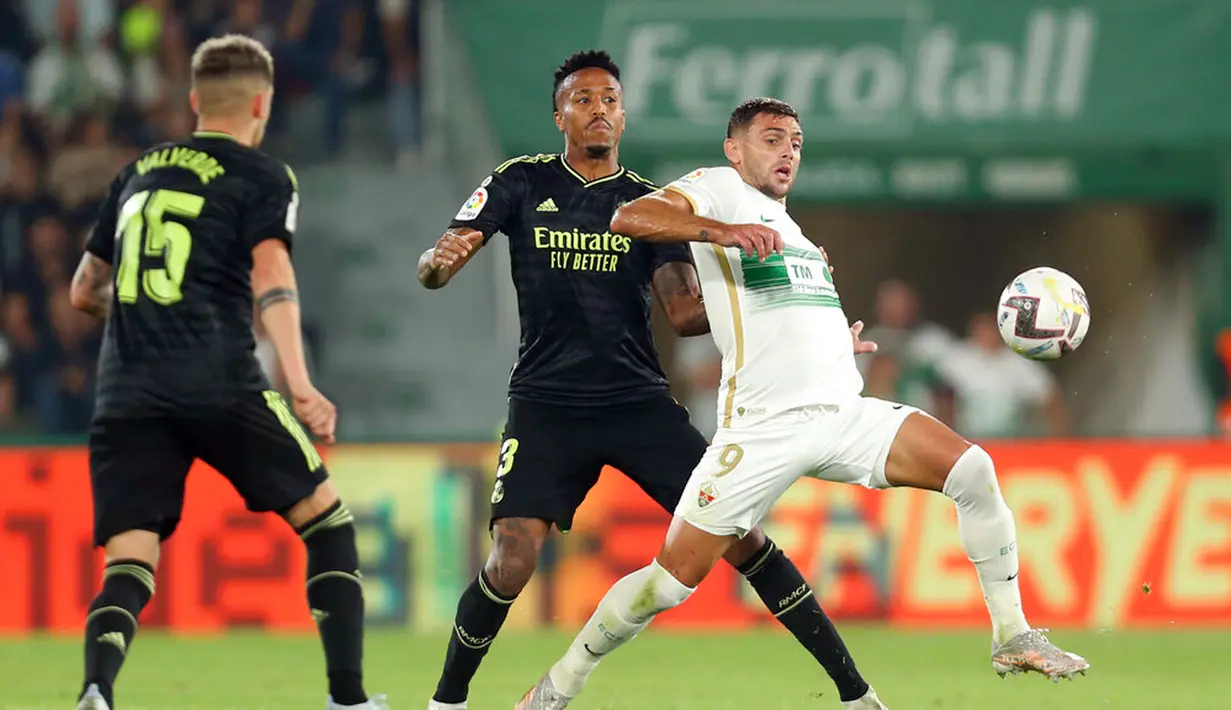 Pemain Real Madrid Federico Valverde (kiri) menyaksikan rekannya Eder Militao (tengah) berebut bola dengan pemain Elche Lucas Boye pada pertandingan sepak bola La Liga Spanyol di Stadion Martinez Valero, Elche, Spanyol, 19 Oktober 2022. Real Madrid mengalahkan Elche dengan skor 3-0. (AP Photo/Alberto Saiz)