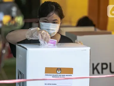 Warga memasukkan surat suara di Tempat Pemungutan Suara (TPS) 69 Pisangan, Ciputat, Tangerang Selatan, Rabu (9/12/2020). Protokol kesehatan dipraktikkan cukup ketat di TPS untuk Pilkada Kota Tangerang Selatan (Tangsel) untuk menghindari penularan COVID-19. (Liputan6.com/Faizal Fanani)