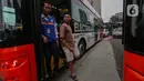 Warga turun dari bus Transjakarta akibat terjebak kemacetan panjang imbas aksi May Day atau Hari Buruh Internasional di kawasan Bundaran HI, Jakarta, Rabu (1/5/2024). (Liputan6.com/Angga Yuniar)