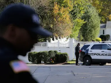 Aparat kepolisian berjaga di depan rumah mantan Menteri Luar Negeri Hillary Clinton dan mantan Presiden Bill Clinton di Chappaqua, New York, Rabu (24/10). Paket bahan peledak ditemukan di kotak surat kediaman Bill dan Hillary Clinton. (AP/Seth Wenig)