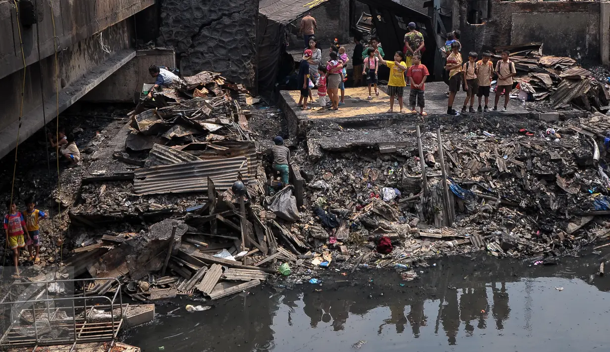 Warga melihat sisa kebakaran yang melanda kawasan Pasar Gembrong, Jakarta, Rabu (5/8/2015). Kebakaran yang terjadi pada Selasa (4/8) lalu membakar sekitar 25 rumah dan toko mainan. (Liputan6.com/Yoppy Renato)