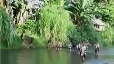 Para siswa terpaksa membuka sepatu dan menggulung celana lebih tinggi agar tak kebasahan.