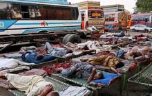 FOTO: Di Tengah Gelombang Suhu Panas Ekstrem, Sopir Bus di Pakistan Ini Justru Tidur Nyenyak di Luar Ruangan