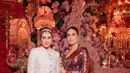 Kakak beradik Kareena Kapoor dan Karima Kapoor tampil luar biasa dalam balutan baju India yang khas. Kareena memilih sari sequin berwarna merah yang semarak, sedangkan Karisma memilih mengenakan atasan Lungi putih dengan kain serasi sebagai rok. [Foto: Instagram/asianweddingmag]