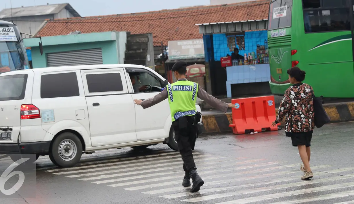 Petugas kepolisian membantu warga menyeberang jalan di Perempatan Cileunyi, Jawa Barat, Jumat (1/7). Mulai banyaknya kendaraan pemudik membuat petugas kepolisian membantu pejalan kaki yang ingin menyeberang. (Liputan6.com/Immanuel Antonius) 