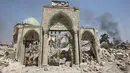 Gerbang Masjid Agung al-Nuri hancur akibat peperangan antara pasukan pemerintah Irak dan kelompok militan ISIS, di Kota Tua Mosul, 30 Juni 2017. Masjid yang dibangun abad ke-12 itu rata dengan tanah usai diledakkan kelompok ISIS. (AHMAD AL-RUBAYE/AFP)