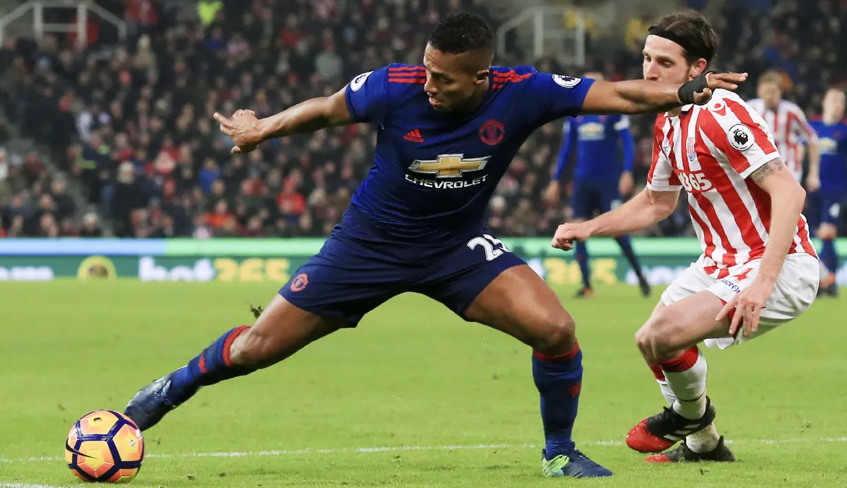 Pemain Manchester United, Antonio Valencia (kiri) mencoba melewati hadangan pemain Stoke City,  Joe Allen pada lanjutan Premier League di Bet365 Stadium, Stoke-on-Trent, (21/1/2017). Setan Merah bermain Imbang 1-1. (AFP/Lindsey Parnaby)