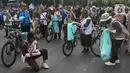 Anggota Praja Muda Karana (Pramuka) menggunakan sepeda bermuatan tong sampah memunguti sampah di jalanan arena car free day (CFD) kawasan Bundaran Hotel Indonesia, Jakarta, Minggu (9/6/2024). (merdeka.com/Arie Basuki)