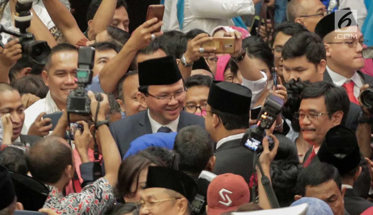 Gubernur DKI Jakarta Anies Baswedan bersalaman dan bertegur sapa dengan gubernur pendahulunya, Basuki Tjahaja Purnama (Ahok) setelah pelantikan anggota DPRD DKI Jakarta periode 2019-2024 di Gedung DPRD DKI Jakarta, Senin (26/8/2019). (Liputan6.com/Faizal Fanani)