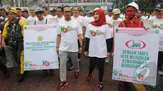 Menteri Hanif Dhakiri didampingi istri Marifah saat kampanye Keselamatan dan Kesehatan Kerja (K3) di Bundaran HI, Jakarta, Minggu (1/3/2015). Kegiatan tersebut untuk meningkatkan kesadaran masyarakat akan pentingnya K3. (Liputan6.com/Herman Zakharia)