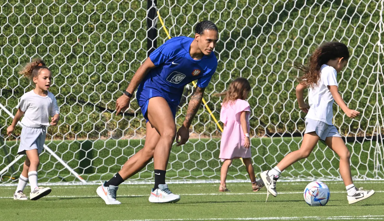<p>Bek Timnas Belanda Virgil van Dijk bermain dengan putrinya saat pertemuan dengan kerabat usai sesi latihan di tempat latihan Universitas Qatar, Doha, Qatar, Selasa (22/11/2022). Pada pertandingan pertama, Belanda berhasil menang dengan skor 2-0 melawan Senegal. (Alberto PIZZOLI/AFP)</p>