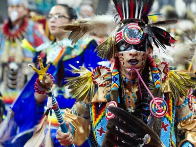 Penari dari Navajo Nation, Ziggy Williams saat mengikuti Grand Entry of the Denver March Powwow di Denver, Colorado (24/3). Acara ini diikuti oleh sekitar 55.000 peserta, terdiri dari penari, penabuh, vendor, dan penonton. (AFP/Jason Connolly)