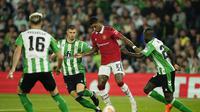 Aksi penyerang Manchester United saat mencoba melewati adangan pemain Real Betis pada leg kedua babak 16 besar Liga Europa 2022/2023, Jumat (17/3/2023) dini hari WIB. (AP Photo/Jose Breton)