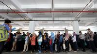 Peserta mengantre untuk pendaftaran ulang ujian CPNS Kementerian Kelautan dan Perikanan (KKP) di kawasan Gambir,  Jakarta, Minggu (8/10). Pendaftaran ujian CPNS ini untuk menempati berbagai formasi di KKP. (Liputan6.com/Johan Tallo)