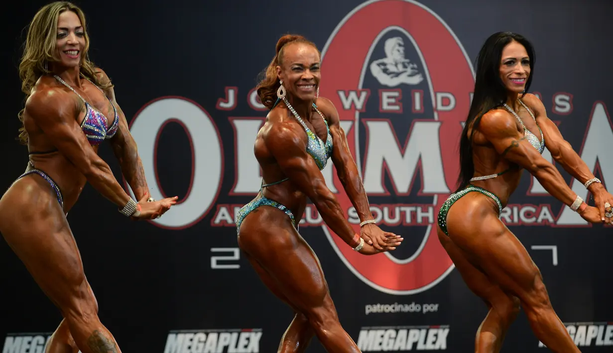Para peserta wanita memamerkan ototnya saat berpartisipasi dalam kompetisi binaraga Mr. Olympia South America di Medellin, Kolombia (18/2). (AFP Photo / Raul Arboleda)