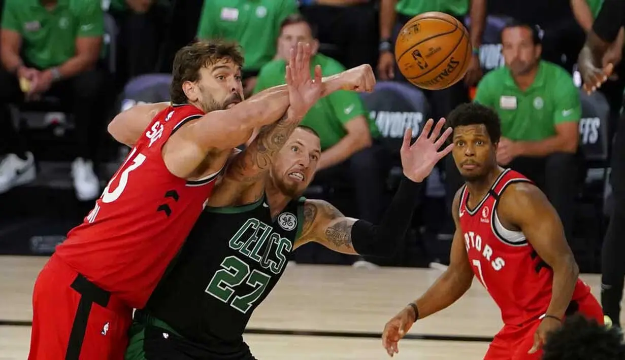 Pebasket Boston Celtics, Daniel Theis, berebut bola dengan pebasket Toronto Raptors, Marc Gasol, pada laga NBA di Lake Buena Vista, Senin (7/9/2020). Boston Celtics menang telak 111-89 atas Toronto Raptors. (AP/Mark J. Terrill)