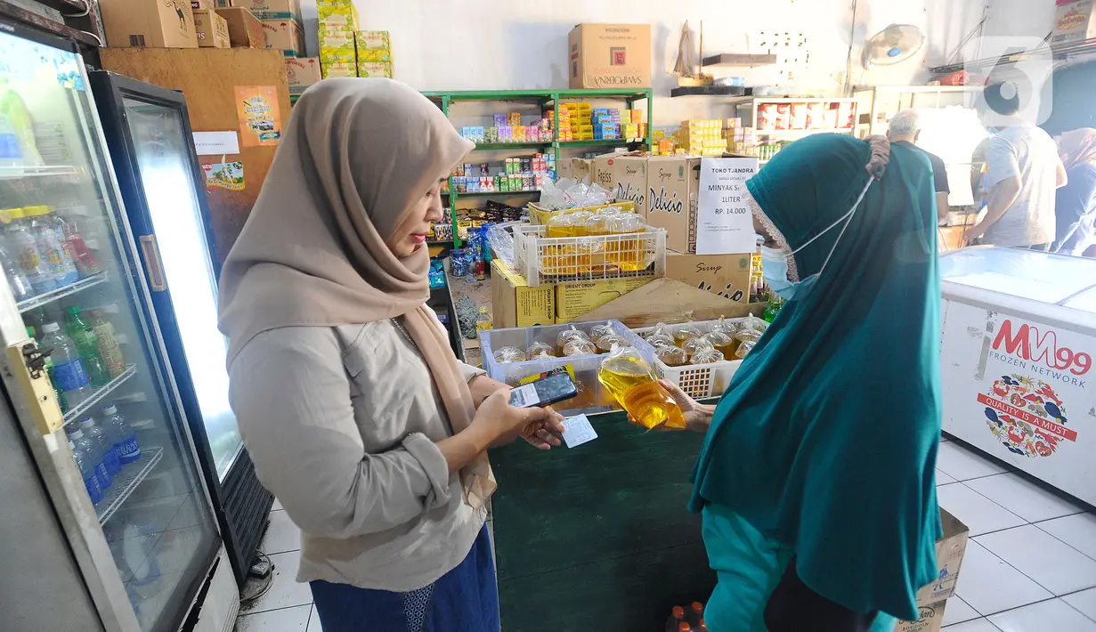 Pedagang melakukan scan KTP pembeli minyak goreng curah di Toko Tjandra, Cinere, depok, Jumat (03/06/2022). Paska dicabutnya kebijakan subsidi minyak goreng curah, pembeli minyak goreng curah di pasaran diwajibkan menyertakan kartu tanda penduduk (KTP) dengan maksimal 1 ktp untuk 2 liter minyak goreng curah seharga Rp 14.000/liter. (merdeka.com/Arie Basuki)