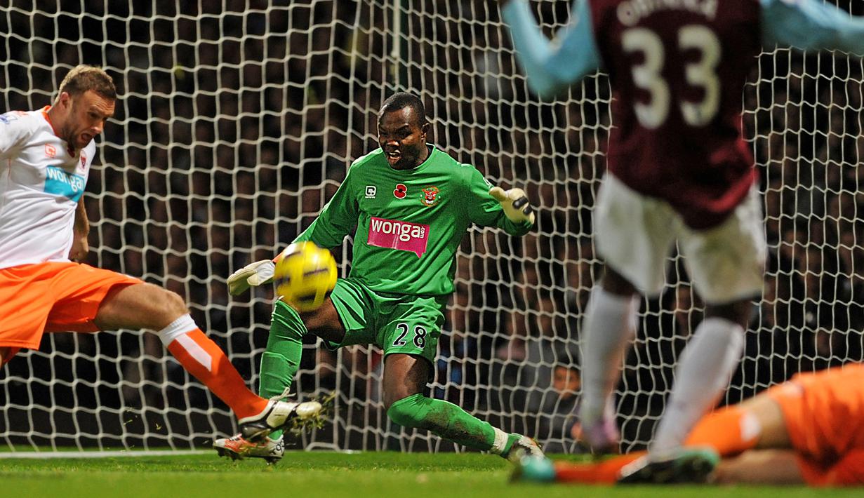 Kiper Blackpool, Richard Kingson (tengah) melakukan penyelamatan dari tendangan striker West Ham, Victor Obinna pada laga Liga Inggris 2010/2011 di Boleyn Ground, Upton Park, London (13/11/2010). Richard Kingson yang berkebangsaan Ghana tercatat pernah memperkuat Birmingham City, Wigan Athletic dan Blackpool di era Premier League Liga Inggris. Birmingham dibelanya hanya semusim (2007/2008) dengan hanya 1 penampilan, Wigan (2008/2009 dan 2009/2010) dengan 4 penampilan, dan Blackpool (2010/2011) dengan 20 penampilan. (AFP/Ben Stansall)